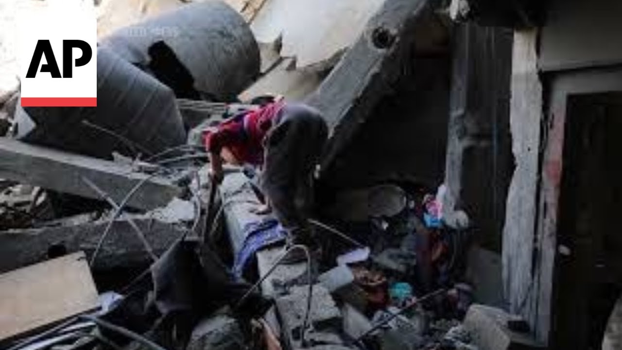Boy searches through mass of concrete rubble after deadly Israeli strike on central Gaza